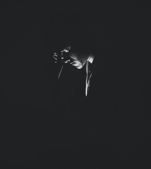 monochrome photography of person on dark room